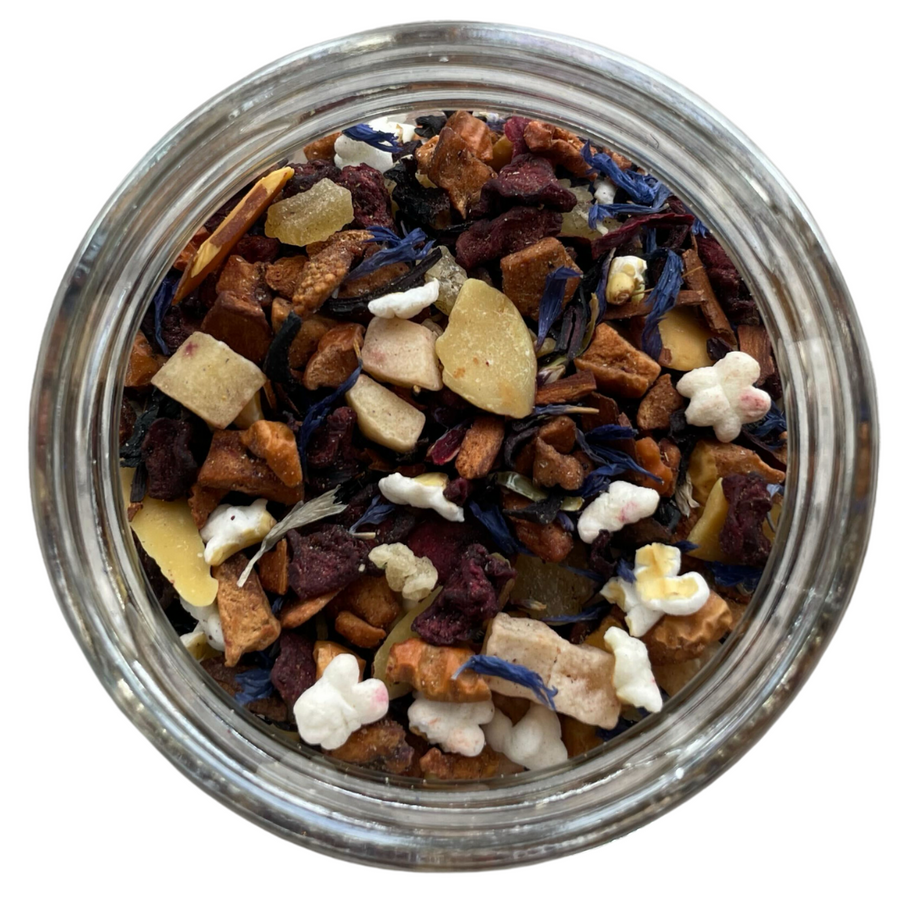 Snow globe herb and fruit tea in a glass jar with a white background