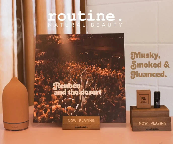 Routine Element drops essential oil blends in a diffuser with a record label displayed in a wooden stand. 