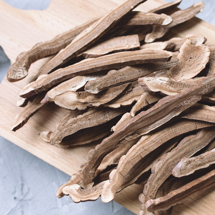 Dried reishi mushroom slices on a wooden cutting board