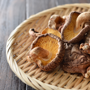 Flat woven basket with dried shiitake mushrooms on top