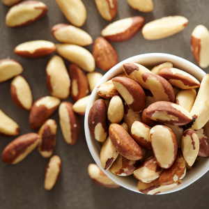 Brazil nuts in a white bowl with a grey background