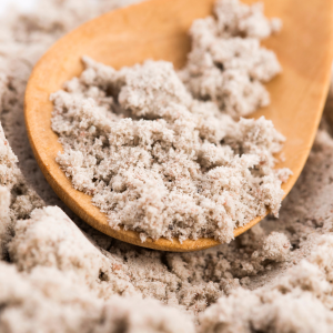 A wooden spoon filled with black salt