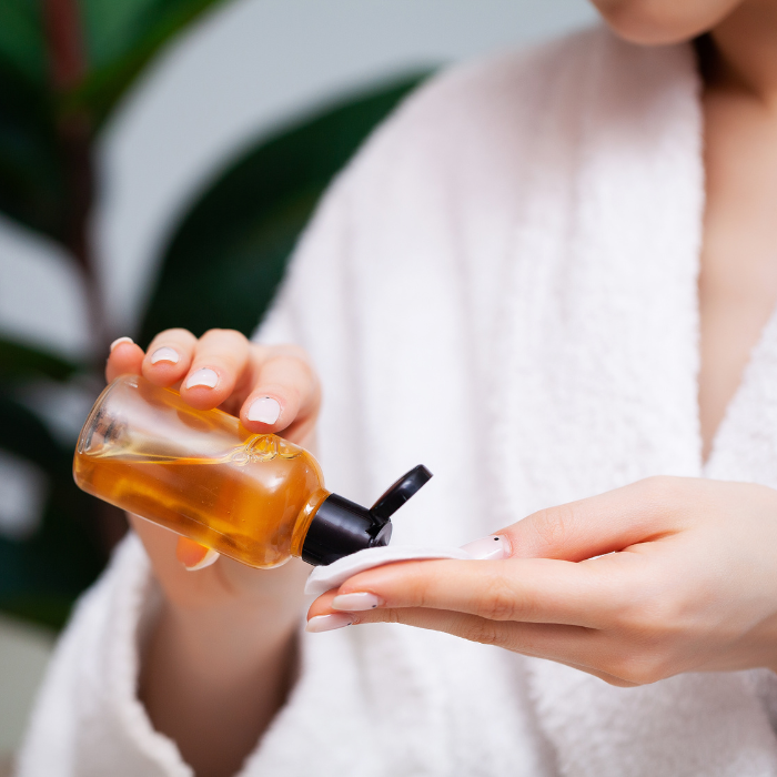 Facial toner being soaked into a facial pad 