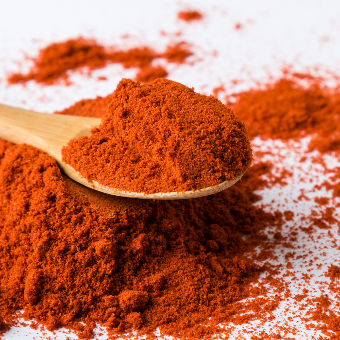 Paprika in a wooden spoon with a white background