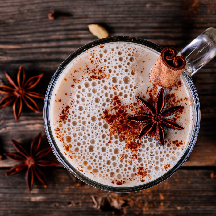 A chai latte on a wooden table with star anise