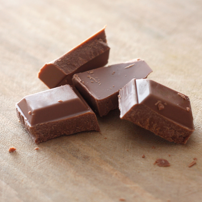 Milk chocolate chunks on a wooden surface