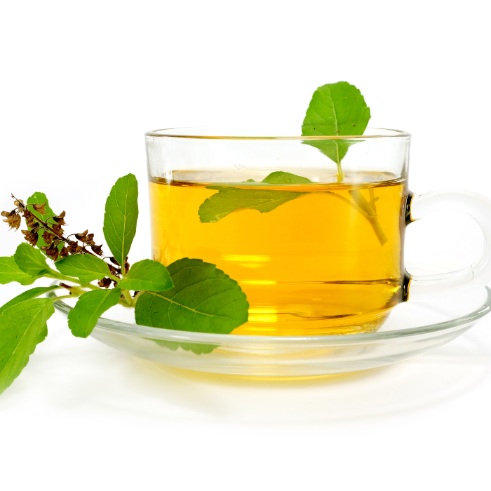 Herbal tea in a glass teacup with fresh herbs