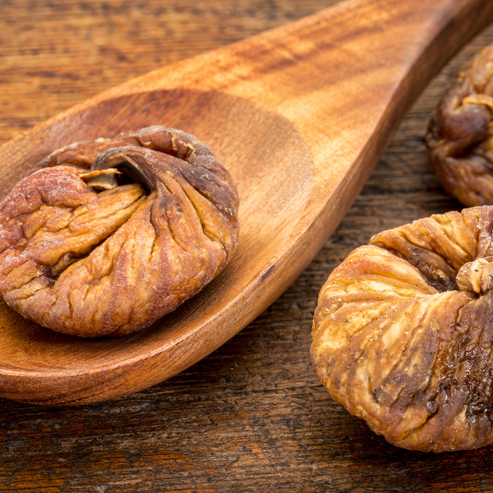 Turkish figs in a wooden spoon and wooden surface