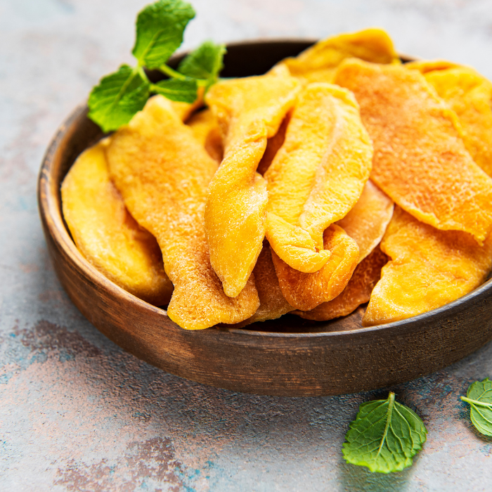 Dried mango slices in a wooden bowl