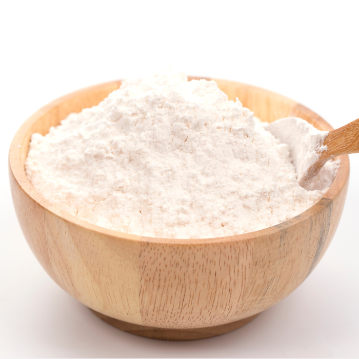 Baking powder in a wooden bowl and a wooden spoon