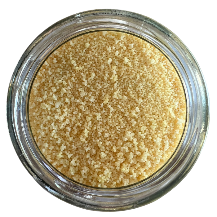 Candelilla wax in a clear glass jar with a white background