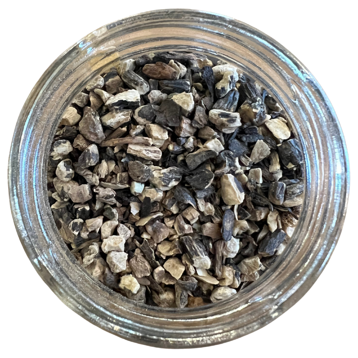 Organic comfrey root in a glass jar with a white background