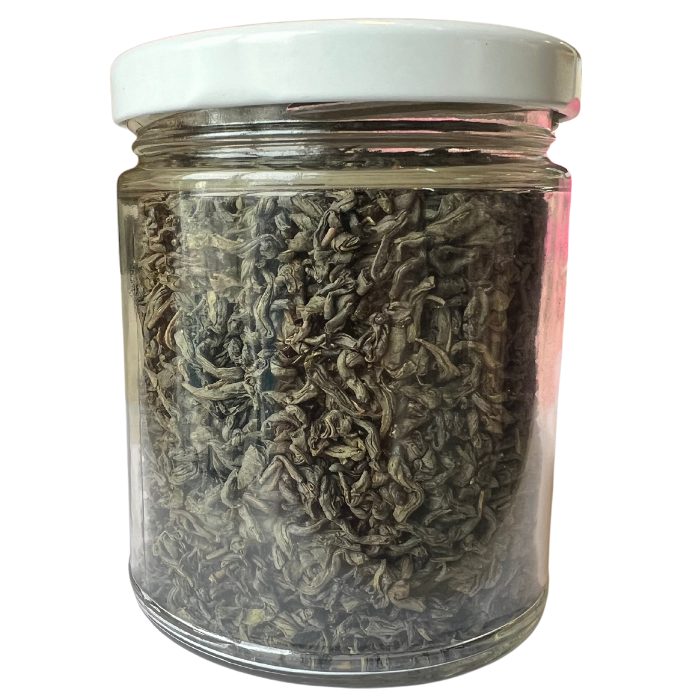 Jasmine golden dragon tea in a glass jar with a white background