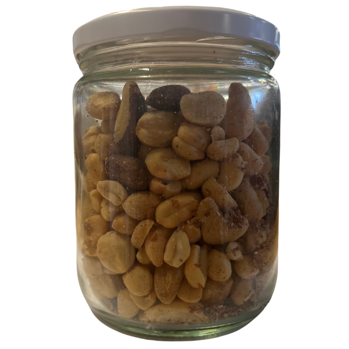 Mixed nuts with peanuts in a glass jar with a white background