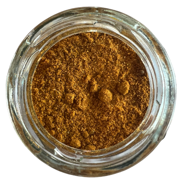 Muni's hot curry mix in a clear glass jar with a white background