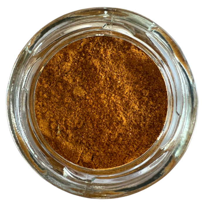 Muni's mild curry mix in a clear glass jar with a white background