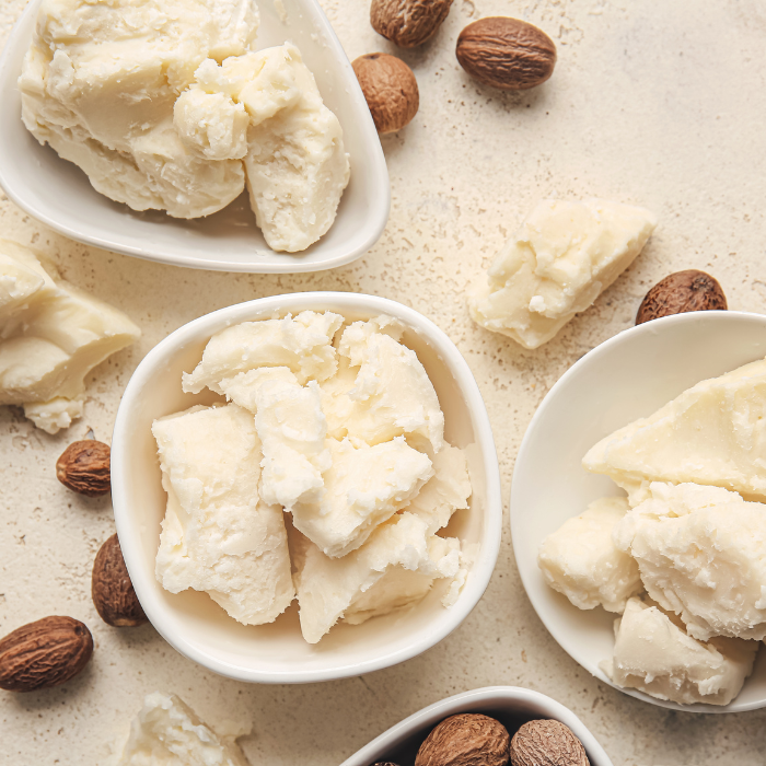 Refined shea butter in white bowls on a beige background