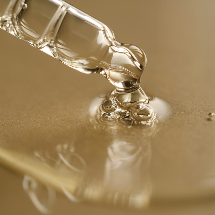 Squalane oil coming out of a glass dropper