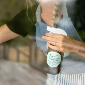 Glass Cleaner Mint Cleaning held by a lady cleaning a window